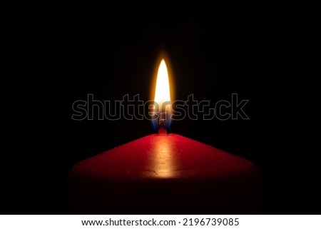 Closeup red candle flame isolated with black background
