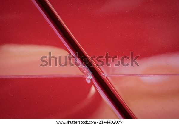 Closeup of red\
car with paint damage, long\
scratch