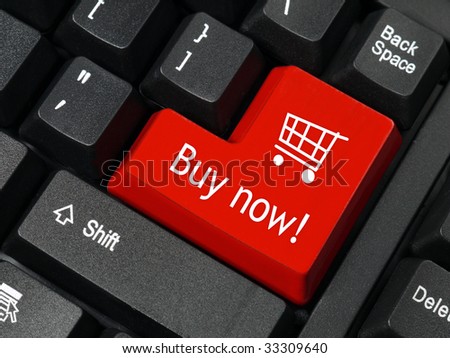 Closeup of red computer keyboard key with shopping cart symbol and Buy Now text