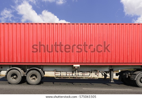 The close-up of red\
container on the truck at the hi-way with the sky.The side of the\
container.