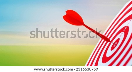 Close-up red dart arrow hitting in target center of dartboard sky background  Business goal or success goal marketing Strategy and business competition concept