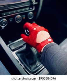 Close-up Of Red Driving Glove On Shift Stick In Car.