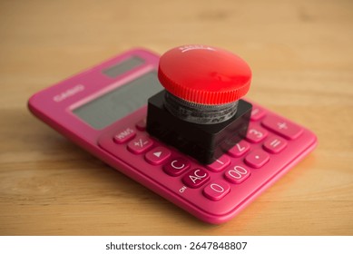 Closeup red emergency button on calculator background. Financial crisis, bankrupt, loss, refinancing, debt restructuring, stop payment, risk management and so on concept.