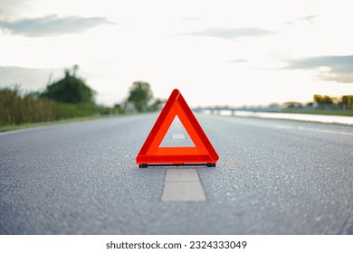 Close-up of red emergency stop sign placed on the road for vehicle accidents or breakdowns for road safety. road safety concept - Shutterstock ID 2324333049