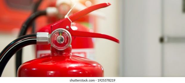 Close-up The Red Fire Extinguishers Tank At The Door Exit Way In The Building Concepts Of Prevent Case For Emergency And Safety Rescue And Fire Training.