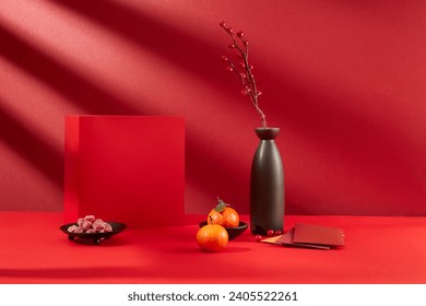 Close-up of a red gift box, a plate of jam, tangerines, lucky money envelopes and a vase of flowers. Empty space for product display. Front view.