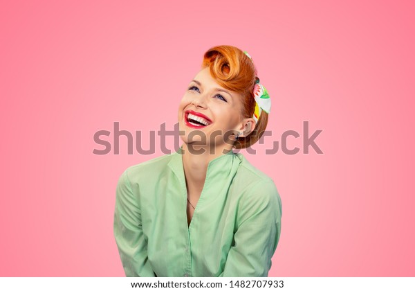Closeup red head\
young woman pretty pinup girl green button shirt laughing smiling\
looking up isolated on pink background retro vintage 50\'s style.\
Human emotions body\
language