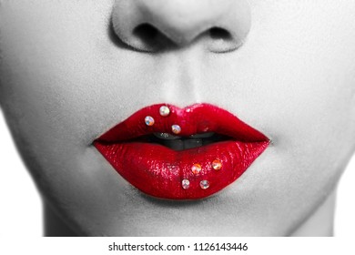 Close-up red lips. Perfect makeup with shiny rhinestones. Ideal image for the advertisement of the professional cosmetics (lipstick, lipgloss etc). Black and white photo.