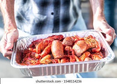 Closeup Of Red Lobsters And Crawfish Seafood With Hands Holding Tray Of Red Shellfish In New Orleans Street Food