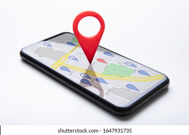 Close-up Of A Red Map Pin Pointer On Black Cellphone Over White Surface