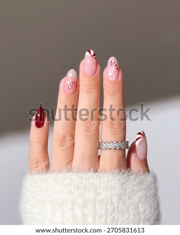 Close-up of red nails with candy and snowflake designs for the Christmas season. Christmas nail art, Candy and snowflake nails, Red holiday manicure