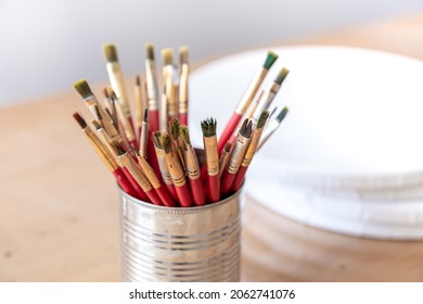 Close-up of red paint brushes in a metal jar. - Powered by Shutterstock