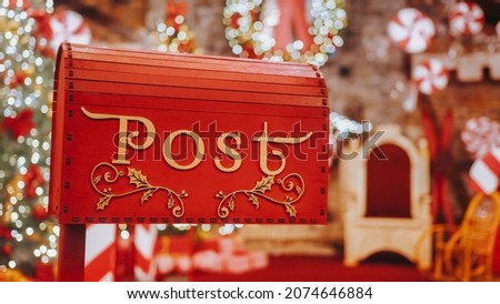 Closeup Red post box for letters to Lapland to Santa Claus. Christmas tradition. Decorative mailbox Santa Claus workshop, wrapped gifts presents boxes on holiday eve in night on xmas background