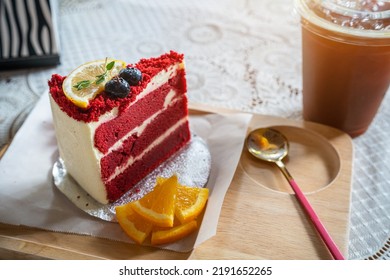 Close-up Of Red Velvet Cake With Fresh Orange And Americano Ice Coffee Or Black Coffee In Wood Desk Office Desk In Coffee Shop At The Cafe In Garden,during Business Work Concept