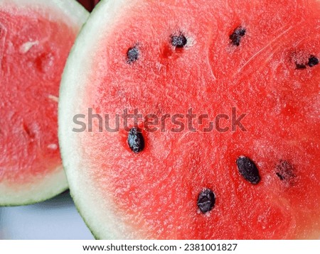 Close-up red watermelon background. Texture of watermelon, red surface with black seeds. Red juicy watermelon close up look.