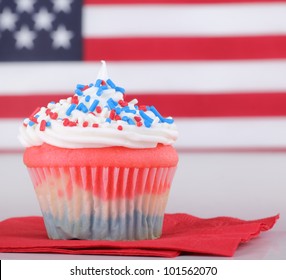 Closeup Of A Red, White And Blue Cupcake With American Flag In Background