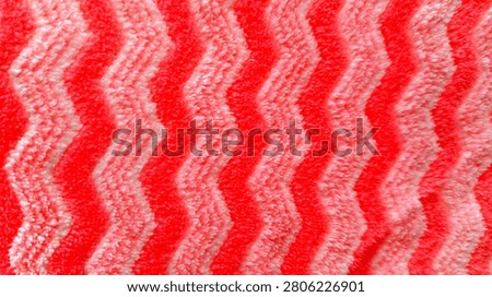 Close-up of a red and white zigzag patterned fabric texture with a soft woven textile surface. Perfect for textile design, fashion, backgrounds, wrapping paper, home decor, and creative stock projects.