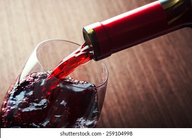 Closeup of red wine pouring in glass