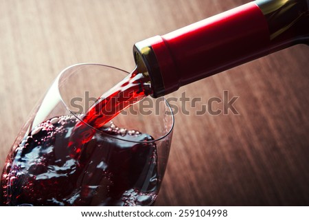 Closeup of red wine pouring in glass