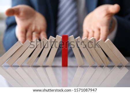 Close-up of red wooden block in centre of slanted colorless bricks. Stand out from crowd and different thinking. Concept of uniqueness and distinction from others