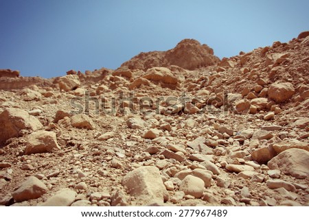 Close-up of reddish rocks in the desert (Ein Gedi - Nahal Arugot - Israel).
Blue sky in the background.
Selective Focus.