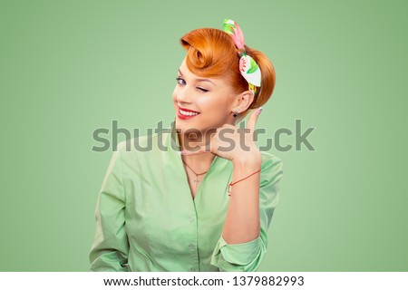 Closeup redhead young woman pinup girl retro vintage 50's style in button shirt winking eye making showing call me sign gesture asking to contact her looking at you camera isolated green background.