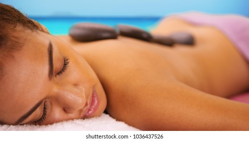 Close-up Of Relaxed Black Woman Laying Down With Hot Stones On Her Back