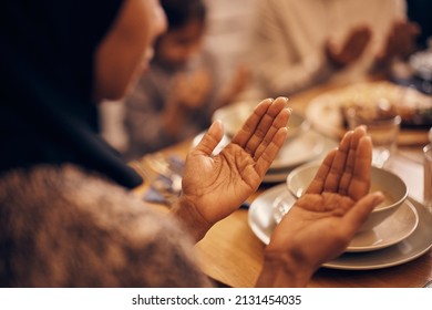 Close-up Of Religious Muslim Woman And Her Family Praying Before The Meal At Dining Table On Ramadan.