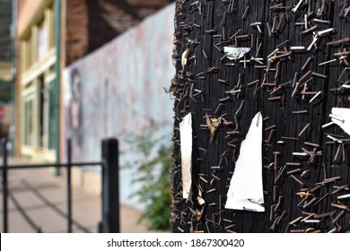 a Closeup of remaining staples from multiple fliers on a bulletin board, artistic textured background, in downtown Bigsby, Arizona