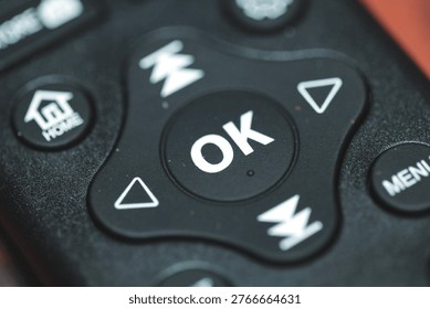 A close-up of a remote control on a table, suitable for use in technology or home decor contexts.