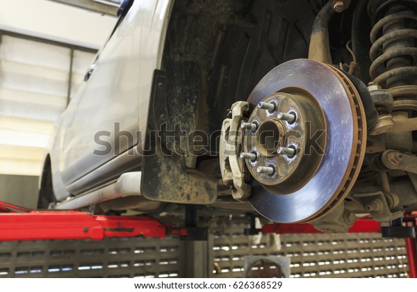 closeup repair disc brakes of car with soft-focus\
in the background. over\
light