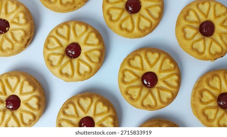 Close-up Repeating Pattern of Round Jam Sandwich Cookies with Heart Designs on White