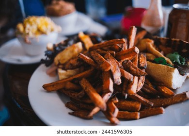 Close-up of restaurant meal with sweet potato fries and sandwich - Powered by Shutterstock