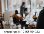 Close-up of a restaurant menu held by a person with a unfocused view of guests dining in the background, capturing the ambiance of a cozy eatery.