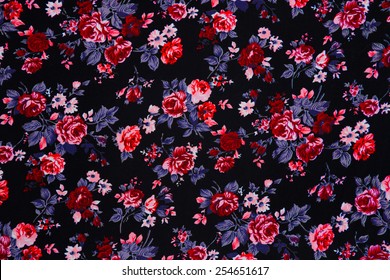 Closeup of retro tapestry fabric pattern with colorful floral ornament with dark background.