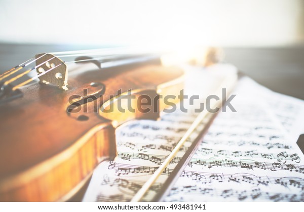 Closeup of retro violin, bow and music sheets.\
Concert concept