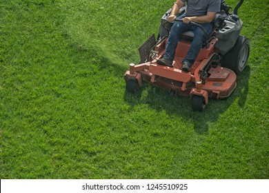 Closeup of a riding landscaper on the lawn mower cutting the grass - Shutterstock ID 1245510925