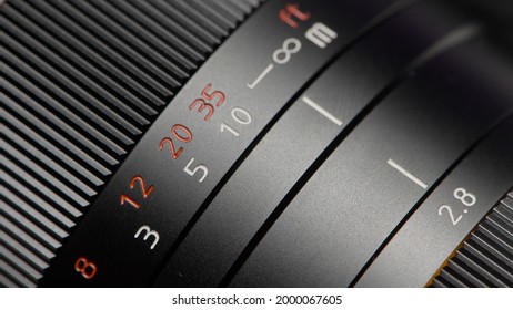 Close-up of ring with settings on lens. Action. Focal length and other settings on professional lens. New lens with values and manual settings