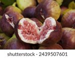 Close-up of a ripe fig fruit split in half with flesh exposed on stacked others, South Korea
