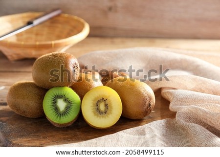 Closeup ripe golden kiwi fruit and green kiwi fruit on wooden background. Healthy fruits concept.