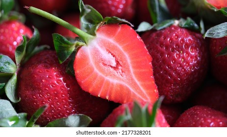 Close-up of ripe red fresh strawberries whole and cut in half. Vitamin and juicy berries or freshly picked fruit. Healthy food and nutrition concept - Shutterstock ID 2177328201