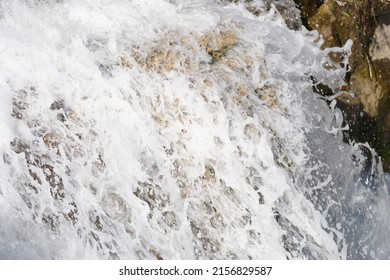 Close-up Of River Waterfall Stream Flows Over Mossy Stones. Bubbling Water Of Cascade With White Foam. Nature And Natural Beauty Concept