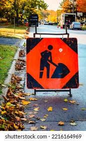 Close-up Of A Road Construction Sign With Work In The Background On A Fall Morning