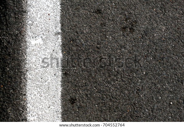 Closeup
of road surface with white paint line,
vertical.