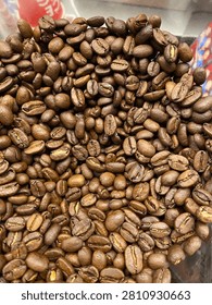 Close-up of roasted coffee beans texture filling the entire frame. Natural brown coffee beans background, perfect for café, beverage, coffee industry, and food-related designs.