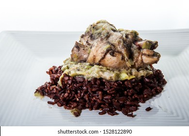 Closeup Roasted Quail With Green Onion Dressing Served On Wild Rice On Modern Plate Against White Background