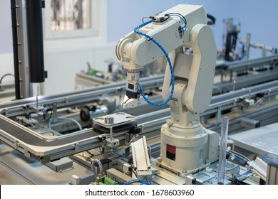 Close-up of robot arm. Industry 4.0 smart factory concept; artificial intelligence in production. Robot arm picks up the product from automated car. Selective focus.