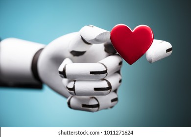 Close-up Of A Robot's Hand Holding Red Heart