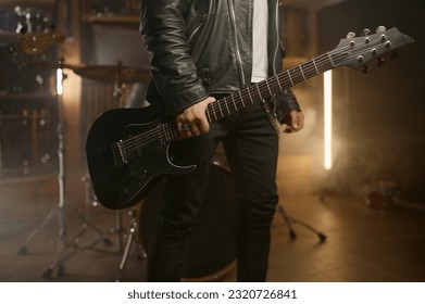 Closeup rock band guitarist holding music instrument over smoky stage background