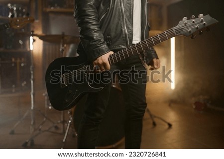Closeup rock band guitarist holding music instrument over smoky stage background